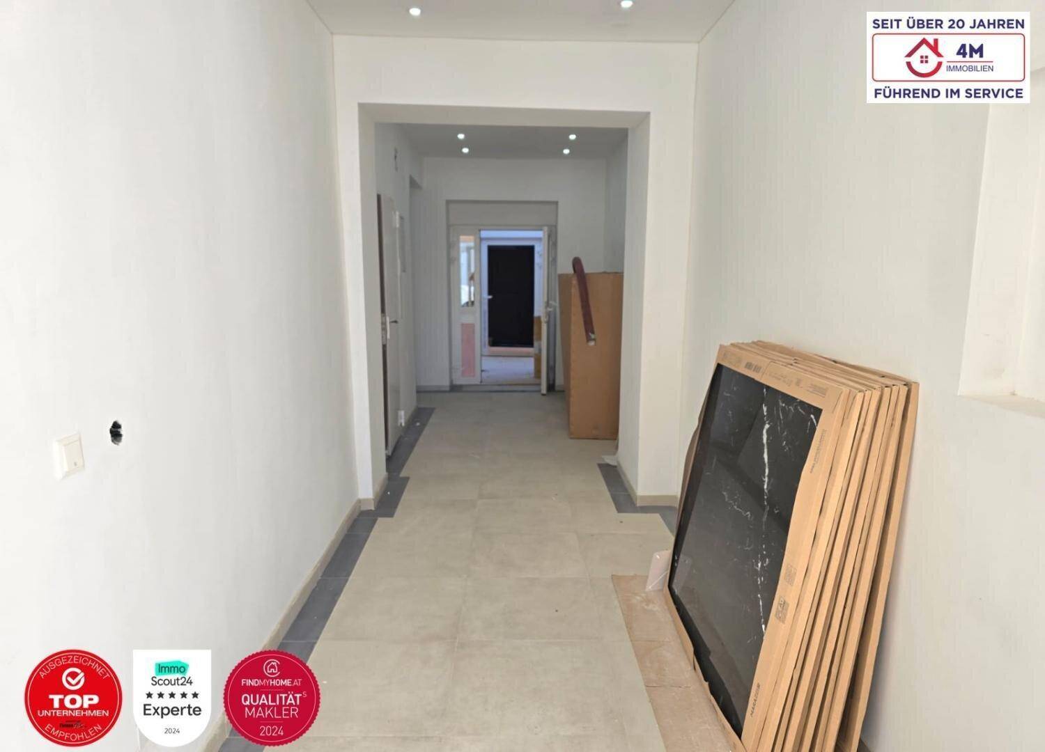 Unfertiger Flur mit gestapelten Fensterrahmen, bereit für den Einbau in die neuen Wohneinheiten.