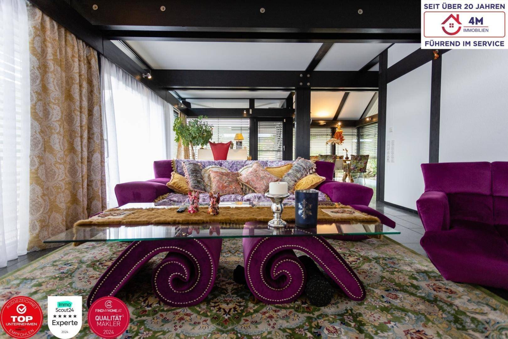 Geräumiges Wohnzimmer mit lila Sofa, Teppich und Blick auf den Essbereich.