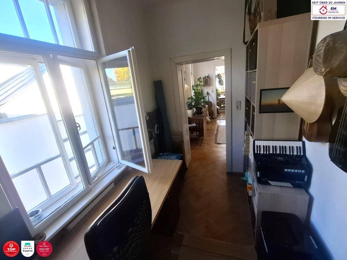 Helles Arbeitszimmer mit Schreibtisch am Fenster und Blick auf die Umgebung.
