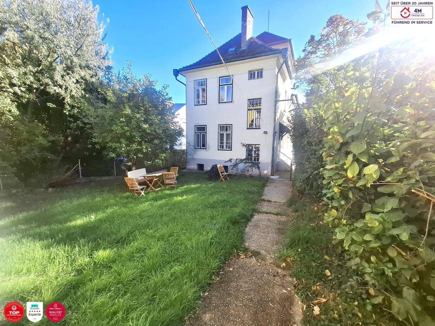 Großer, gepflegter Garten hinter dem Haus mit Rasenfläche und Sitzgelegenheiten.