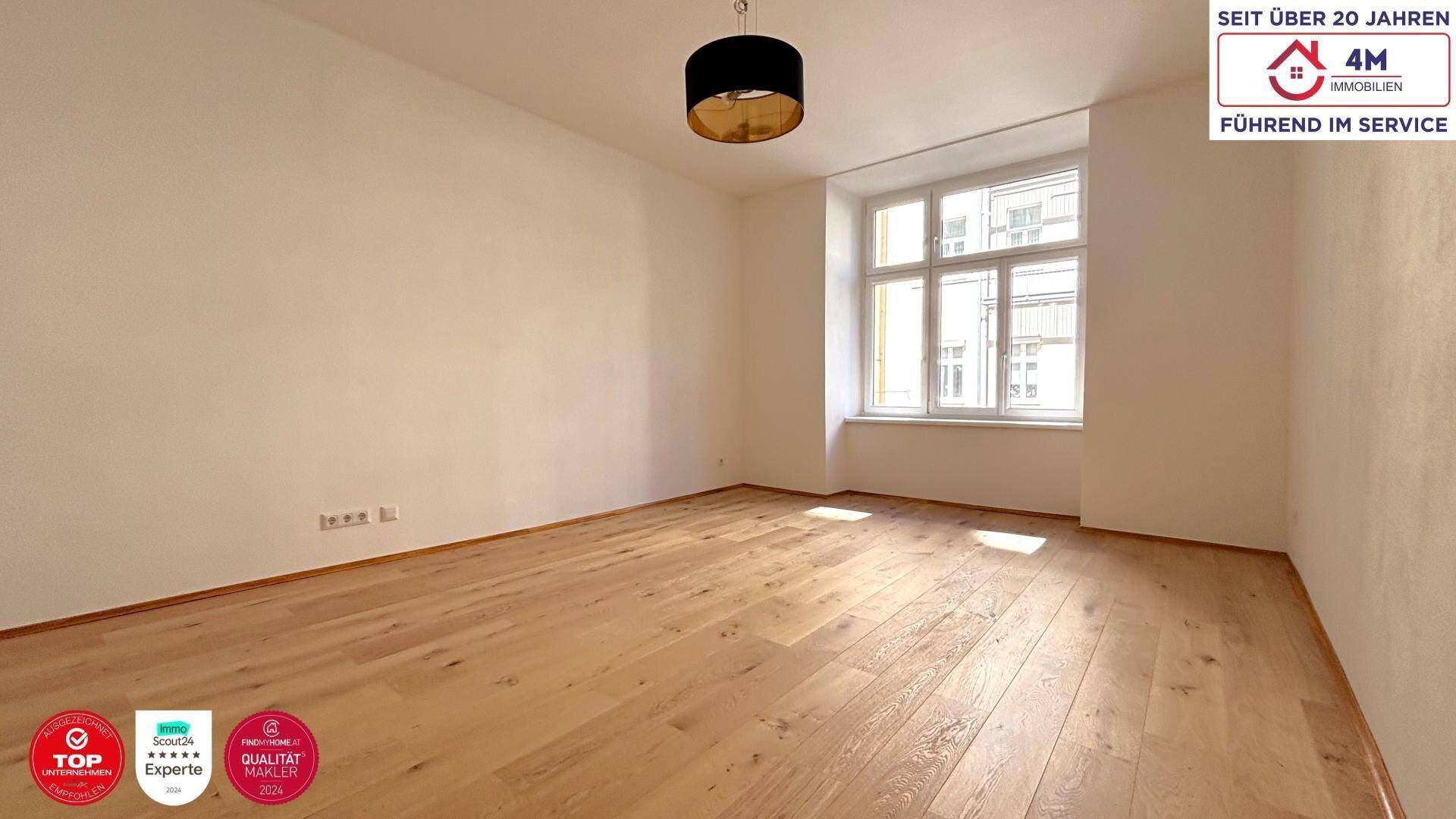 Helles Zimmer mit neuem Holzboden und großem Fenster, bereit zur individuellen Gestaltung.