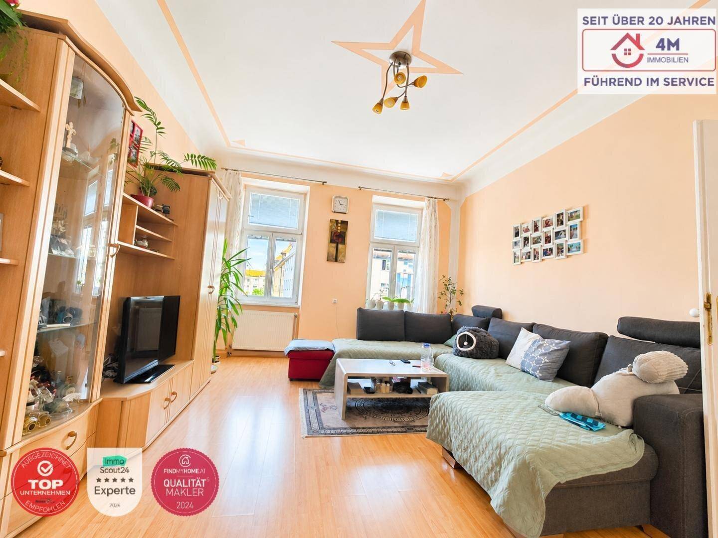 Gemütliches Wohnzimmer mit großem Ecksofa, Holzboden und freundlicher Wandfarbe.