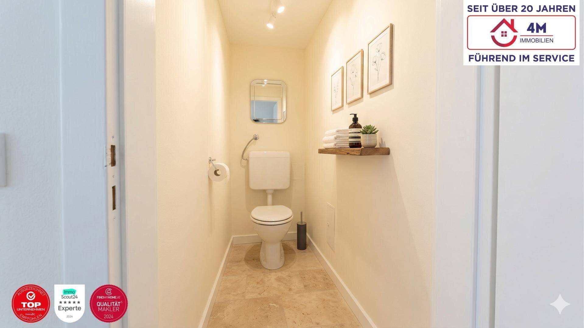 Kleines Gäste-WC mit Toilette, kleinem Waschbecken und Fliesenboden.