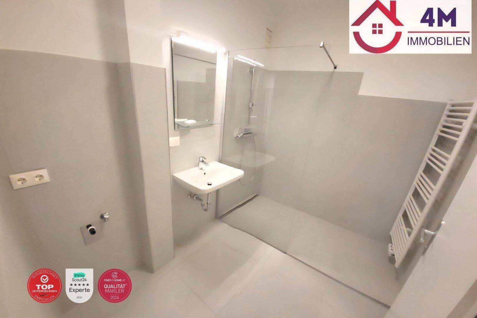 Modernes Badezimmer mit ebenerdiger Dusche, Waschbecken und beheiztem Handtuchhalter.
