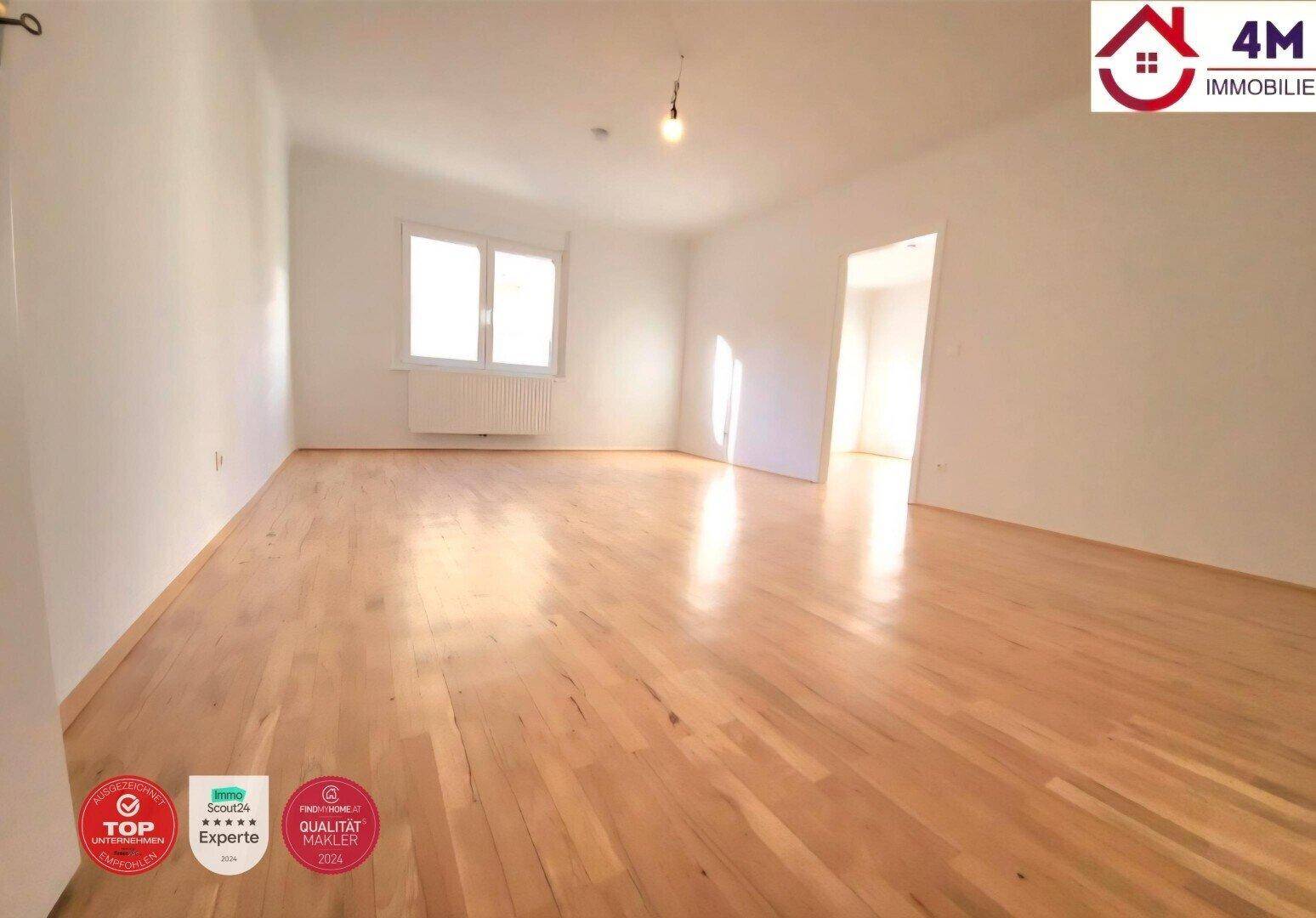 Geräumiges, helles Zimmer mit Holzparkett und einem Fenster, ideal für Wohn- oder Schlafbereich.