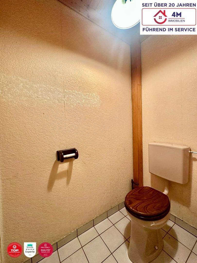 Separate Toilette mit Fliesenboden und einfacher Ausstattung.