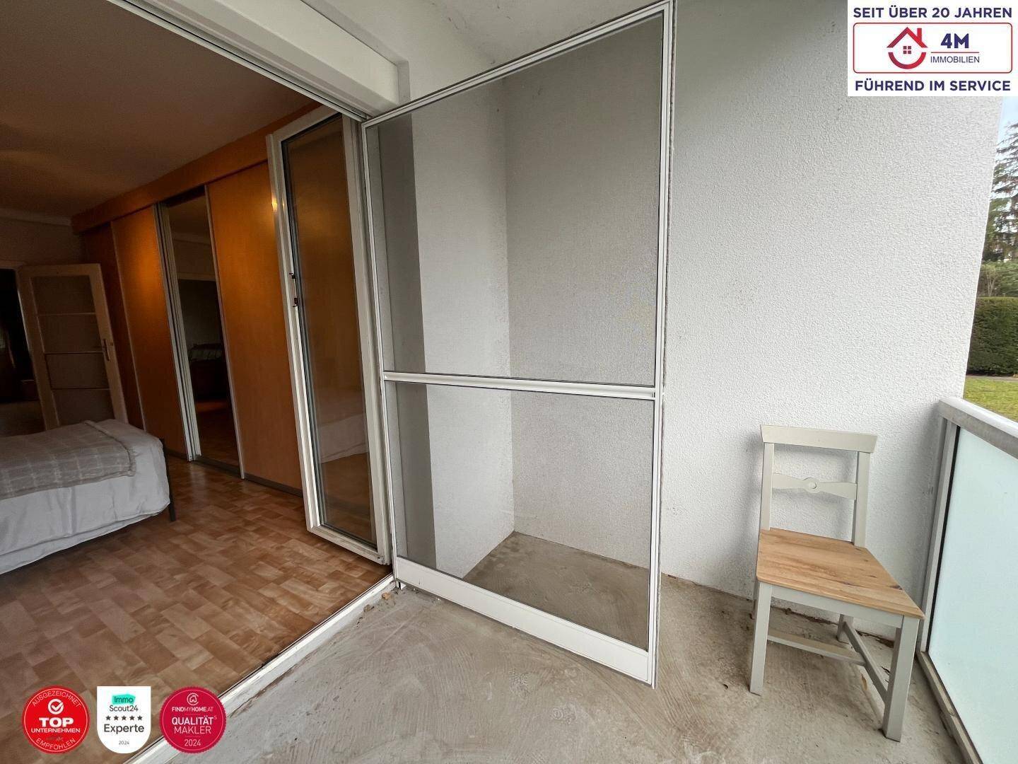 Balkon mit Fliesenboden und Blick auf die Umgebung.