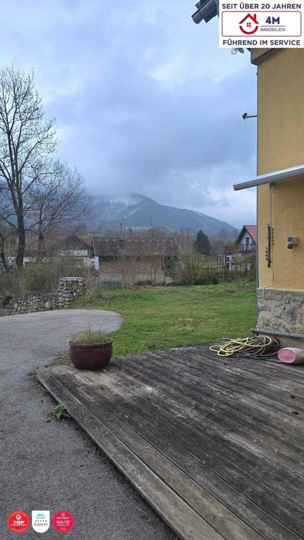 Hölzerne Terrasse mit Blick auf die Berge und die umliegende grüne Landschaft.