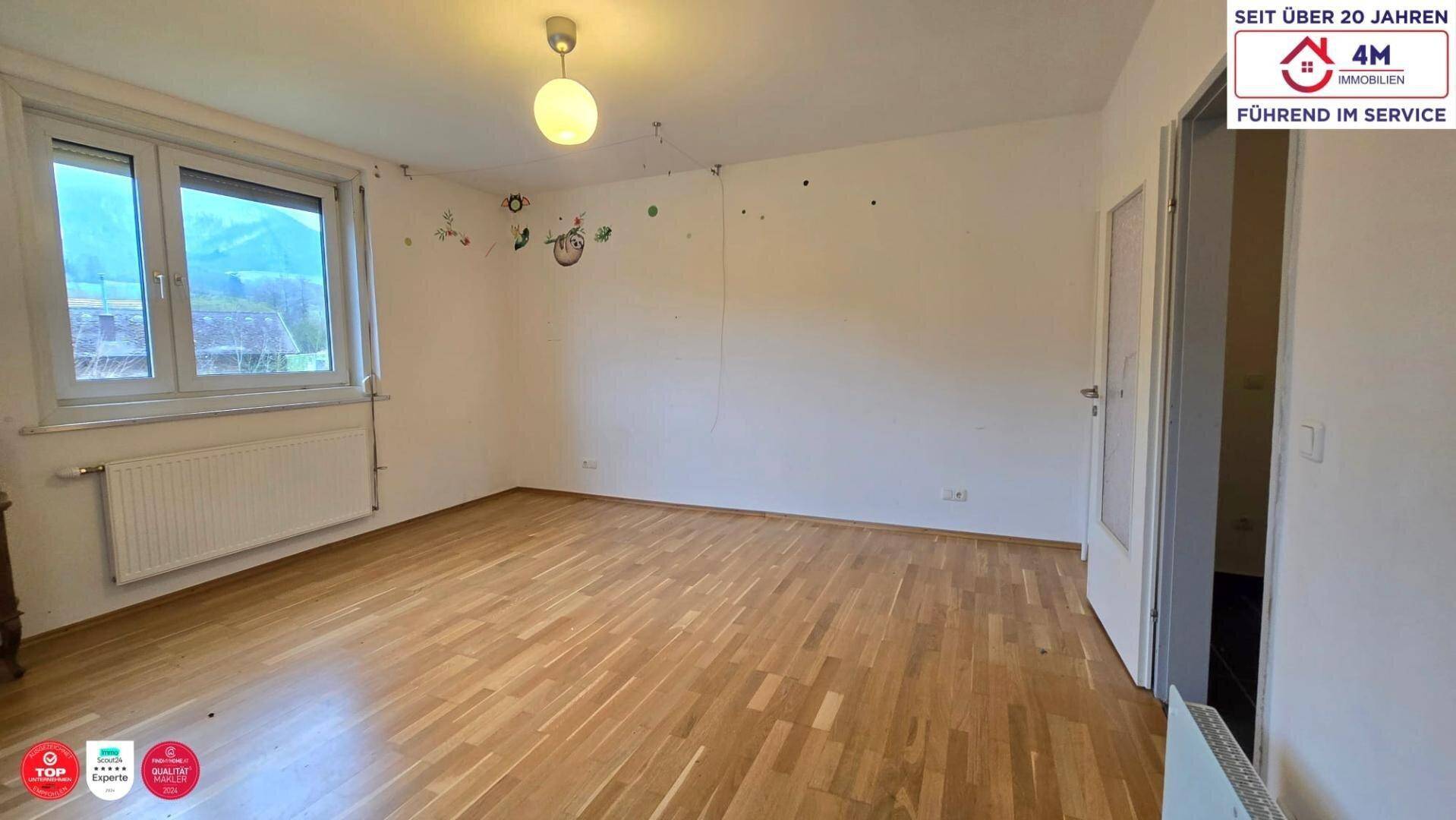 Geräumiges Zimmer mit Holzparkettboden und Fenster, bietet vielseitige Nutzungsmöglichkeiten.