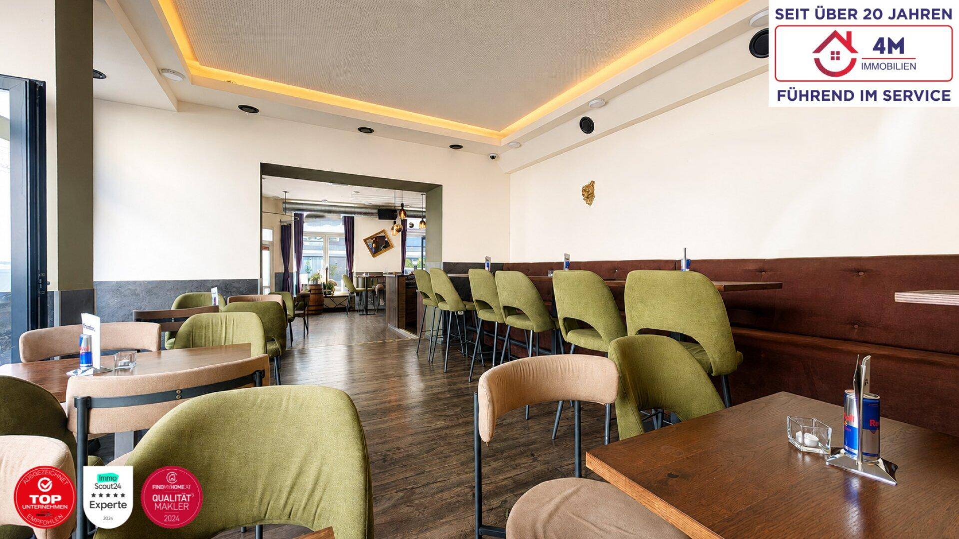 Heller Restaurantraum mit verschiedenen Sitzbereichen, hohen Decken und indirekter Beleuchtung.