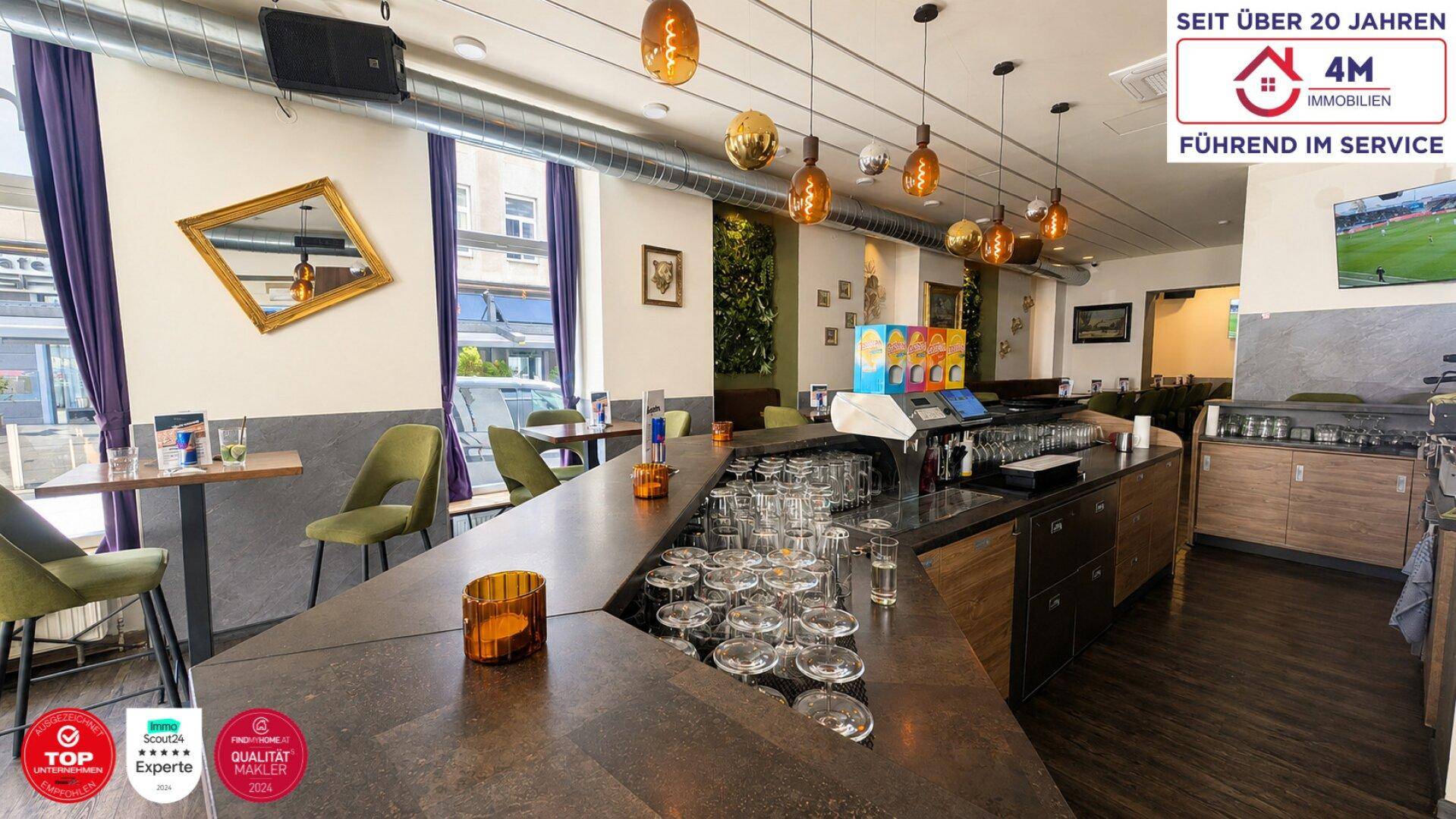 Moderne Bar mit langer Theke, stilvollen Hängelampen und Blick auf die Straße durch große Fenster.