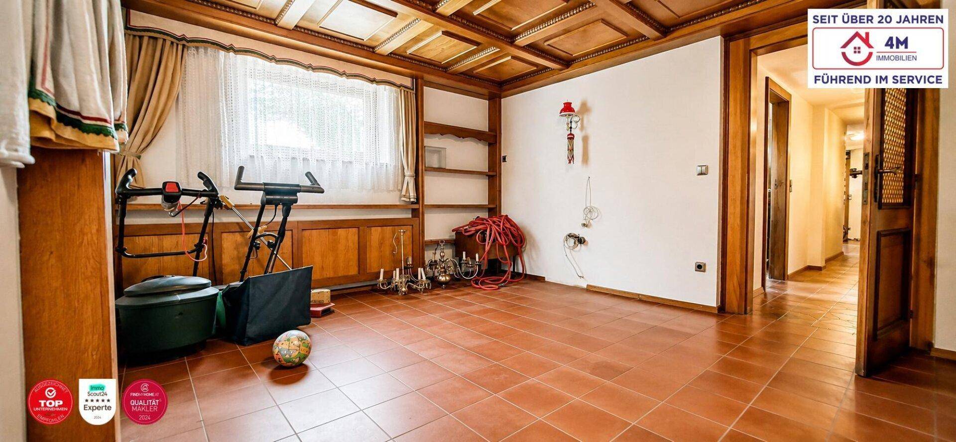Vielseitiger Raum mit Holzkassettendecke, Fliesenboden und Stauraum.