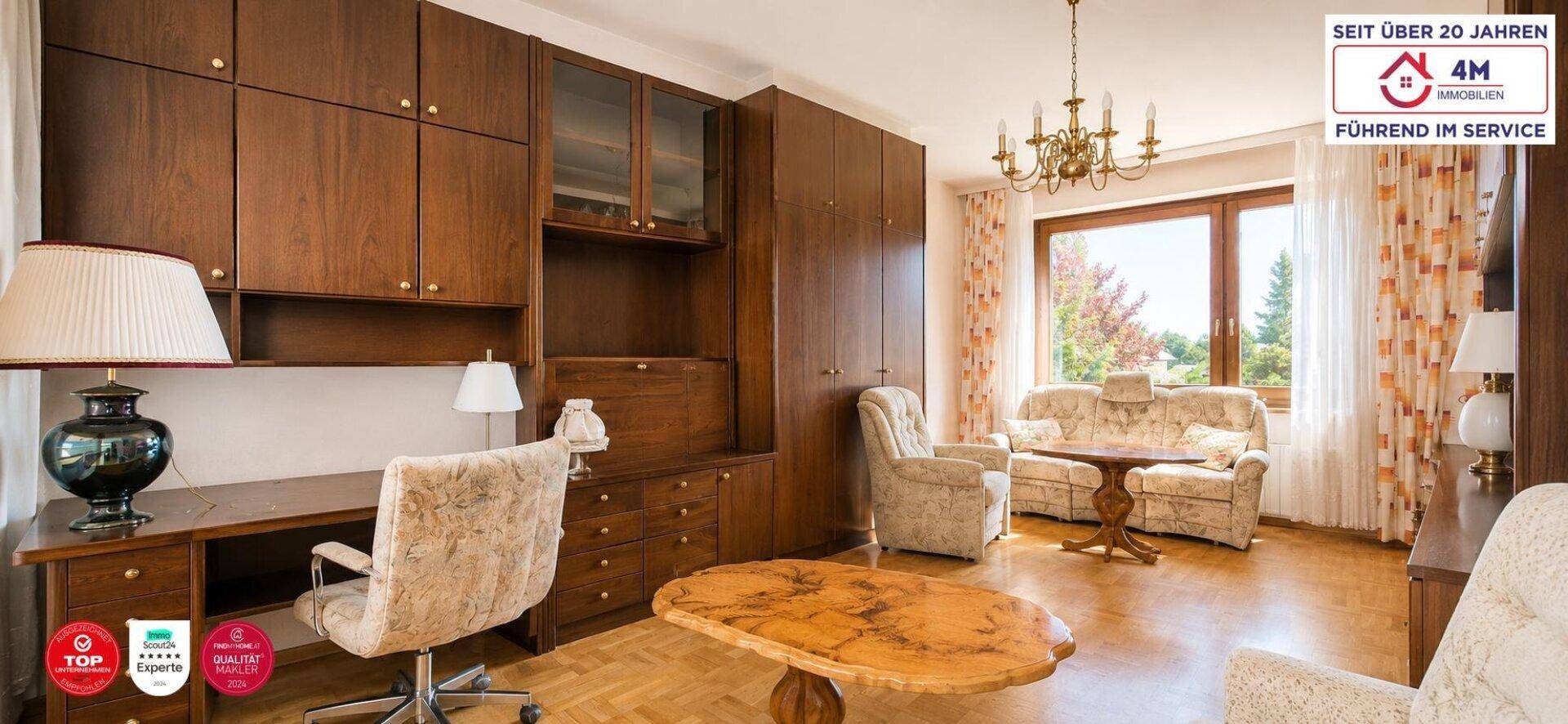 Gemütliches Wohnzimmer mit umfangreichen Holzschränken, Schreibtisch und bequemen Sitzmöbeln.