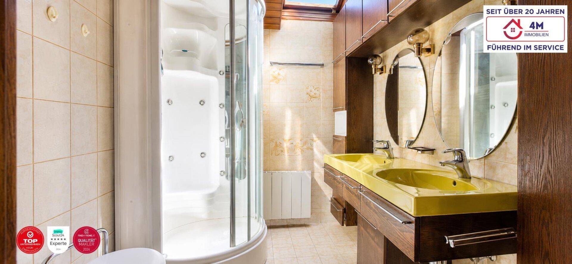 Modernes Badezimmer mit Duschkabine, Doppelwaschbecken und Oberlicht für natürliches Licht.