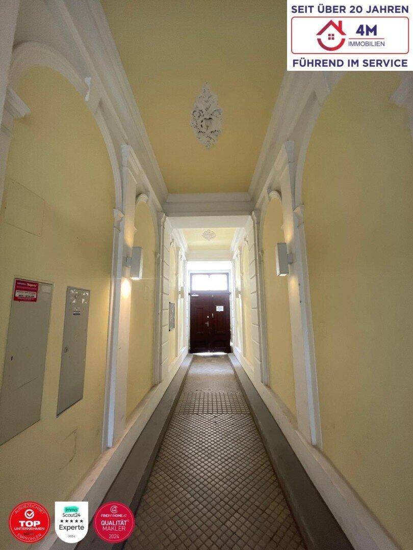 Historischer Eingangsbereich mit Rampe, Stuckdecke und Zugang zur Wohnung.