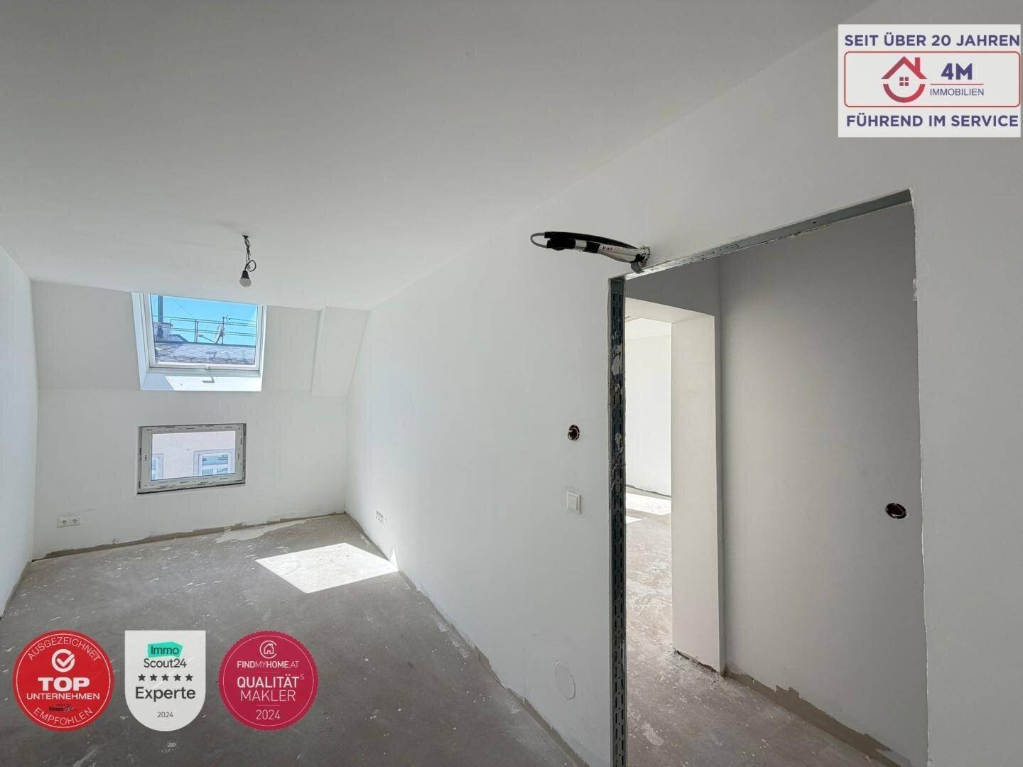 Heller, unfertiger Raum mit einer Türöffnung und einem Dachfenster, das den Raum mit Licht füllt.