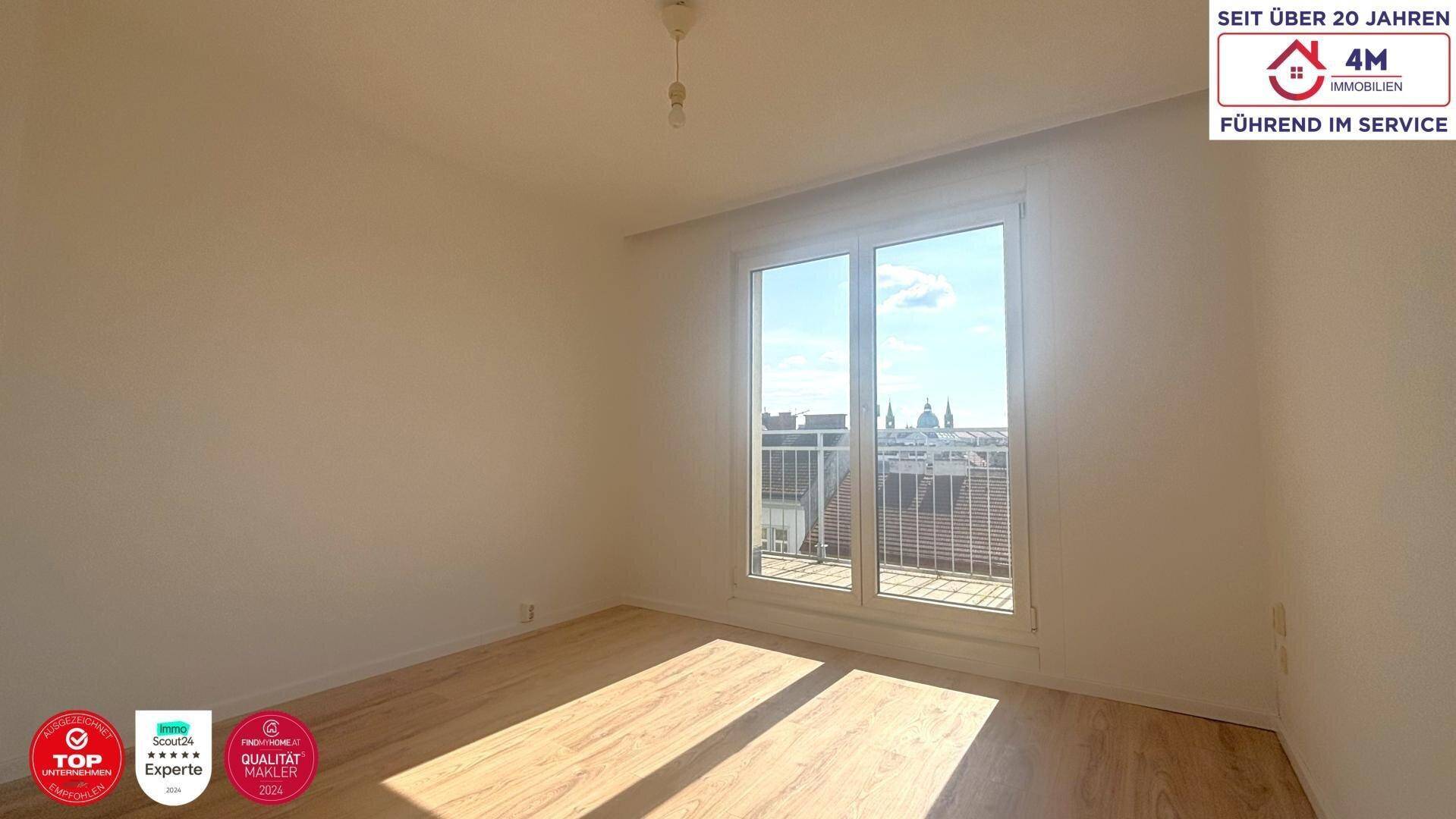 Lichtdurchflutetes Zimmer mit Holzboden und Balkontür, ideal für ein Schlafzimmer.