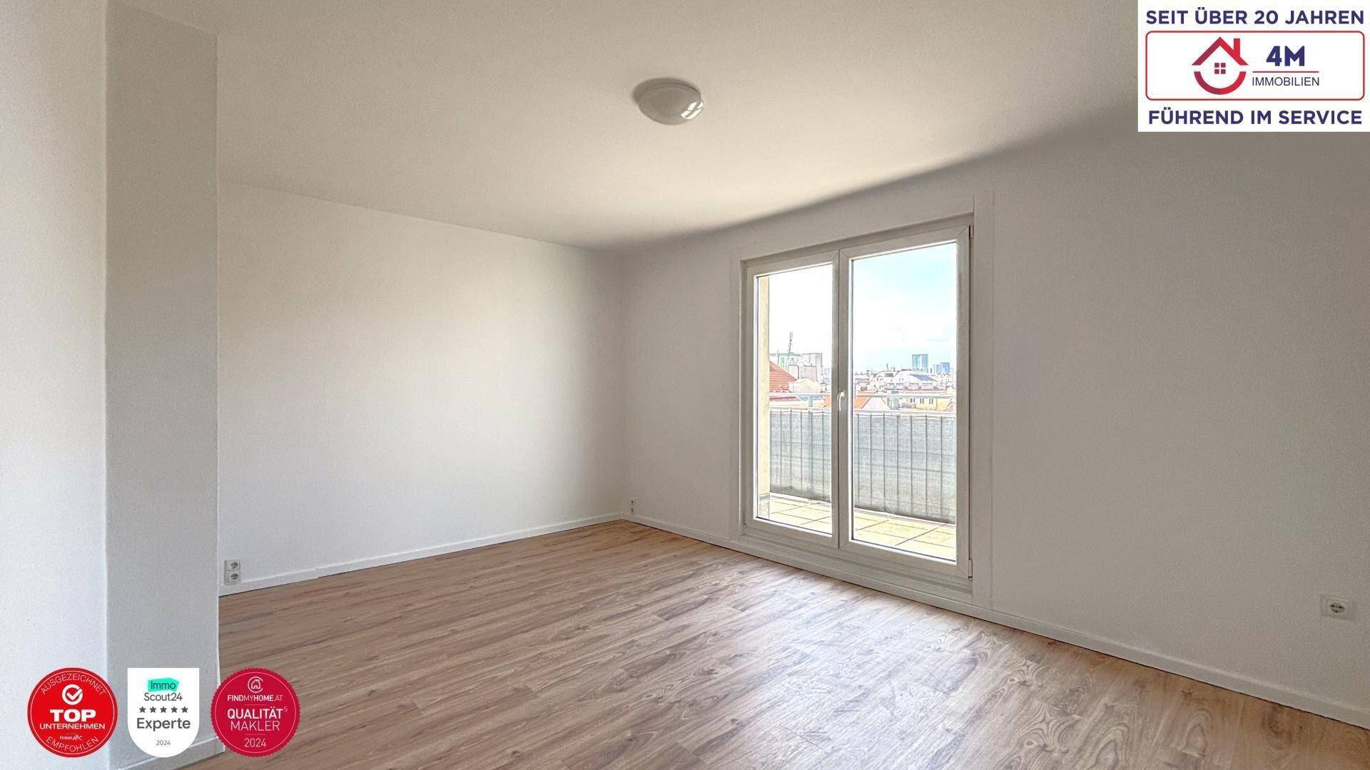 Helles Zimmer mit Holzboden und Zugang zu einem Balkon, bietet einen weiten Blick.