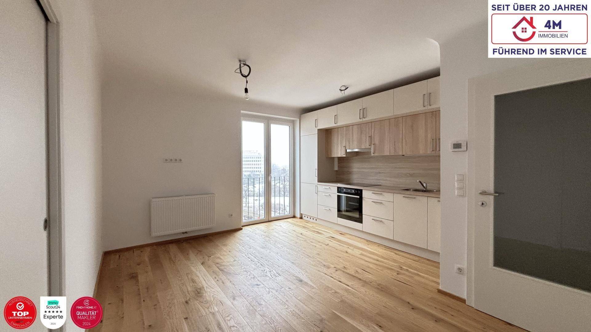 Offene Küche mit Holzboden und Zugang zu einem französischen Balkon, hell und modern.