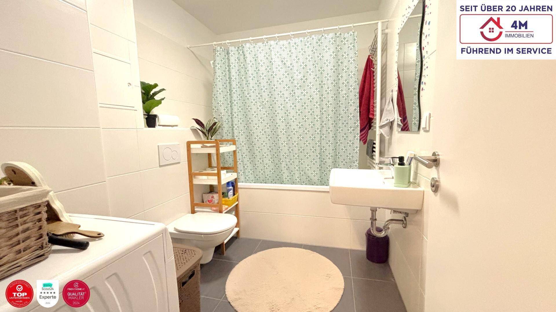 Funktionales Badezimmer mit Badewanne, Duschvorhang, Waschbecken und Toilette, inklusive Waschmaschine.