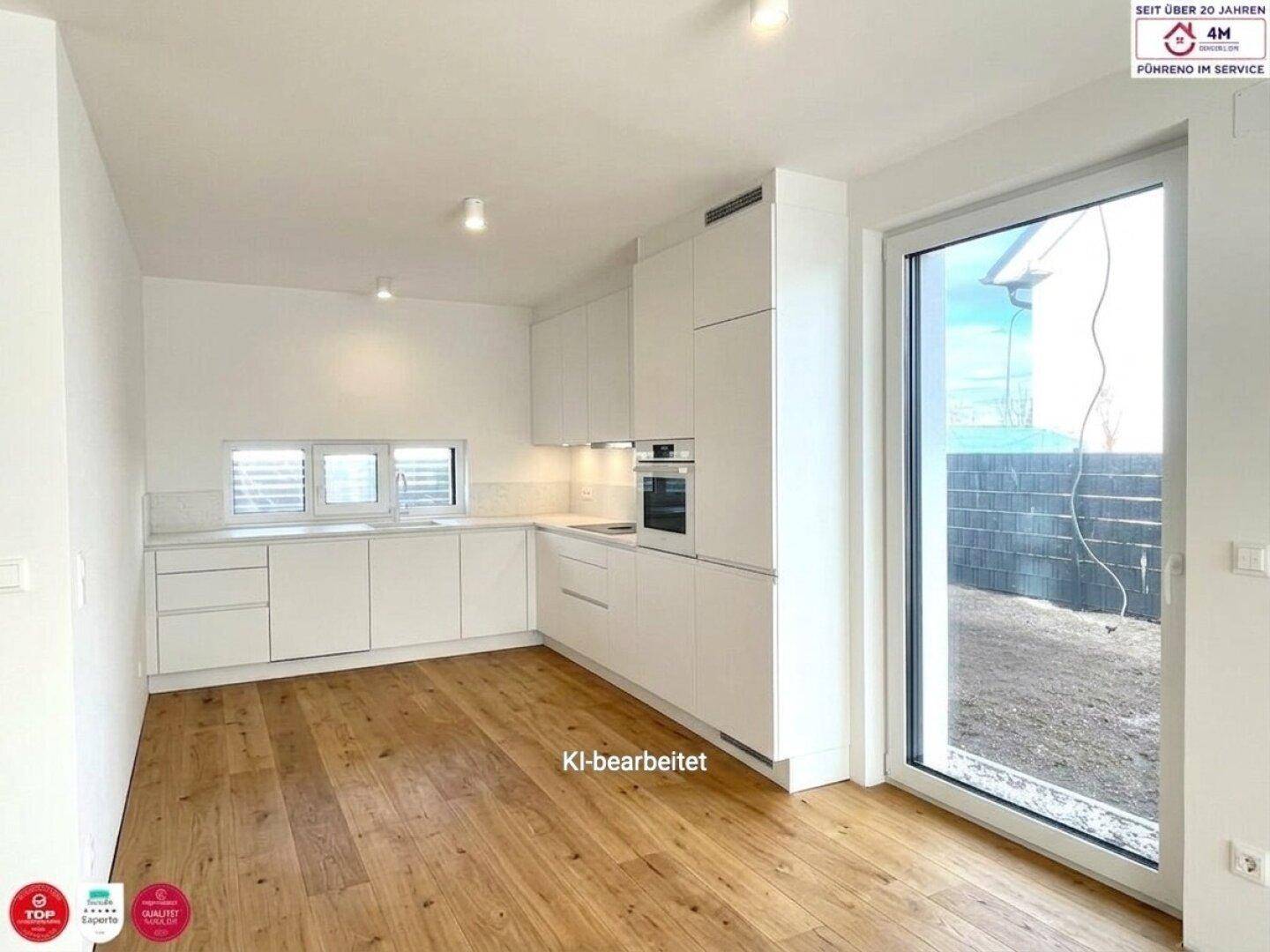 Helle, moderne Küche mit weißen Schränken, Holzboden und Zugang zum Außenbereich.