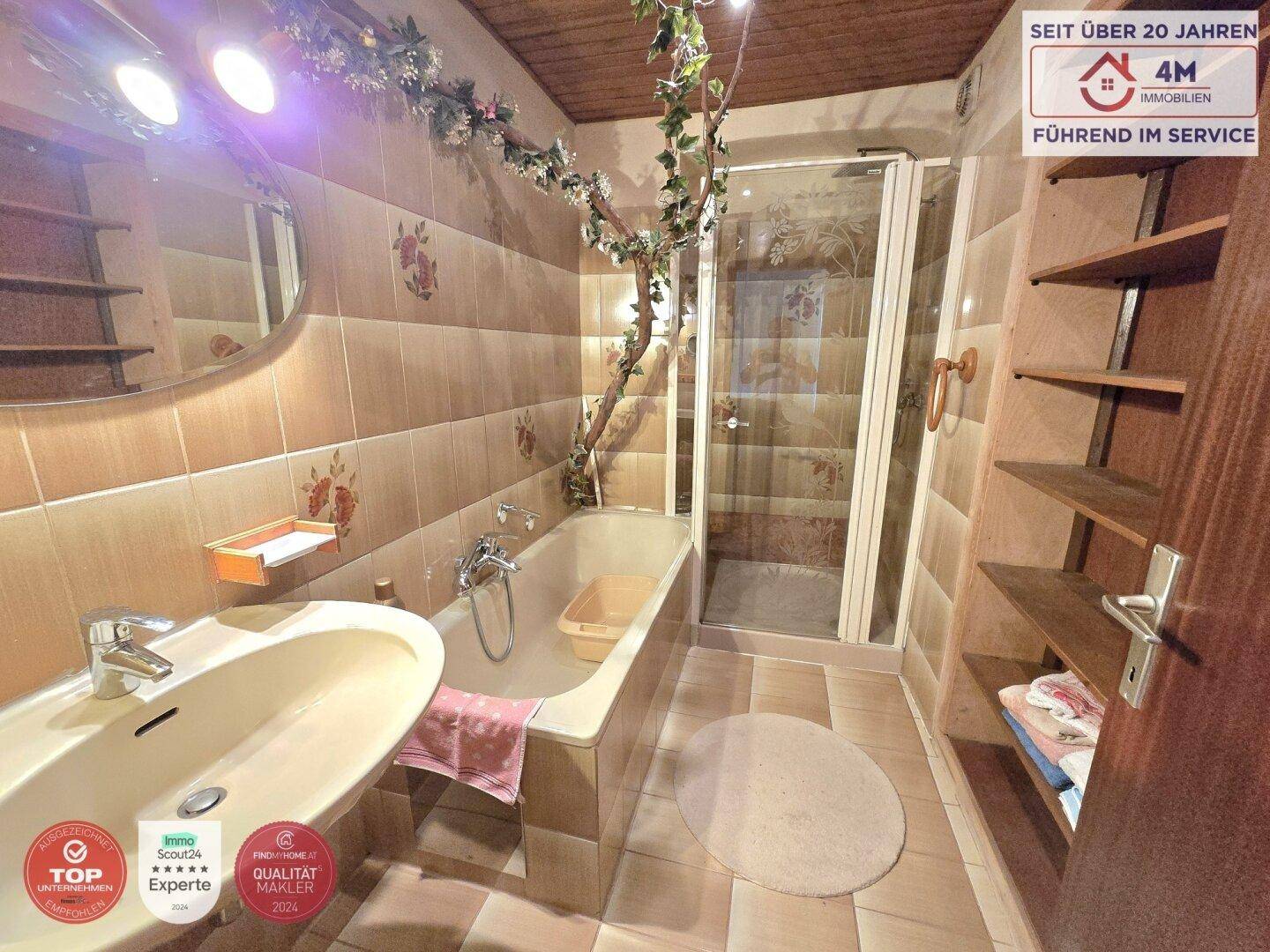 Badezimmer mit Badewanne, Duschkabine und traditionellen Fliesen in warmen Farbtönen.