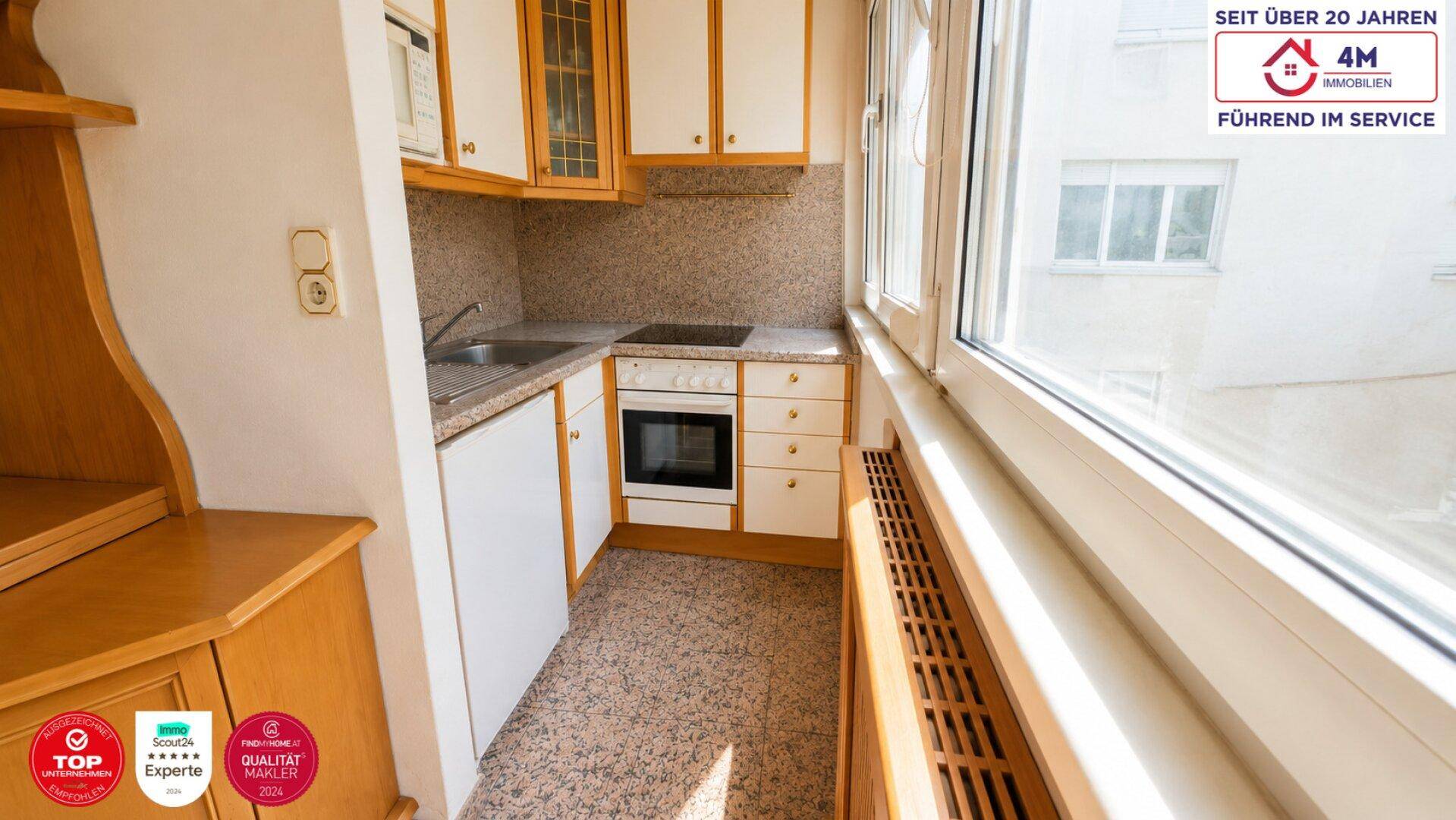 Kleine Küche mit Einbauküche, Fenster und Blick nach draußen.