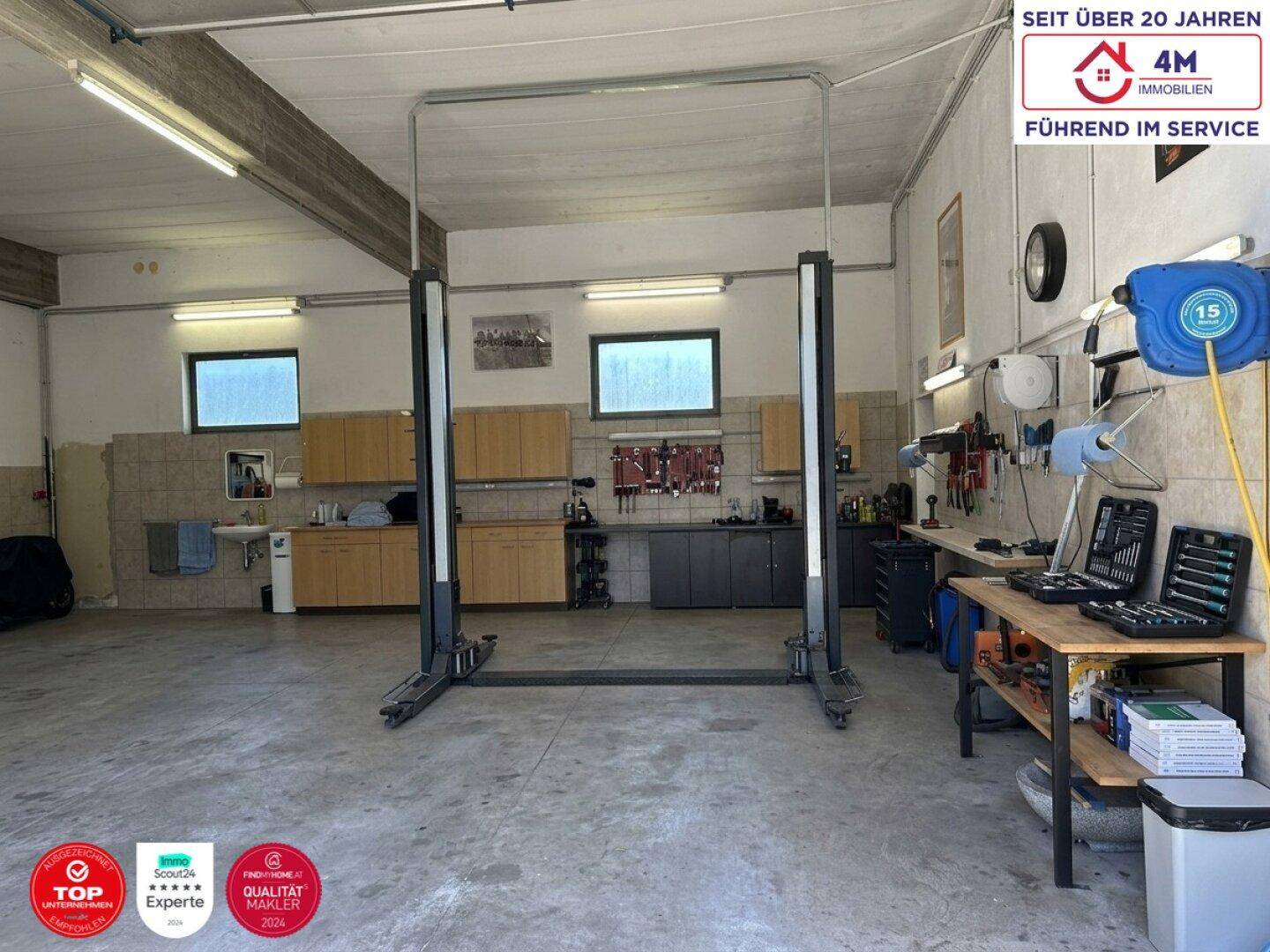 Geräumige Garage mit Hebebühne und Werkstattbereich, ideal für Fahrzeugwartung.