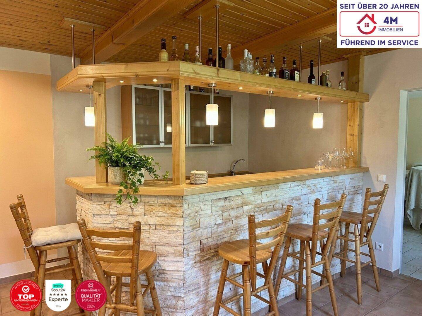 Gemütliche Hausbar mit Holzverkleidung, Steindekor und Barhockern für gesellige Abende.