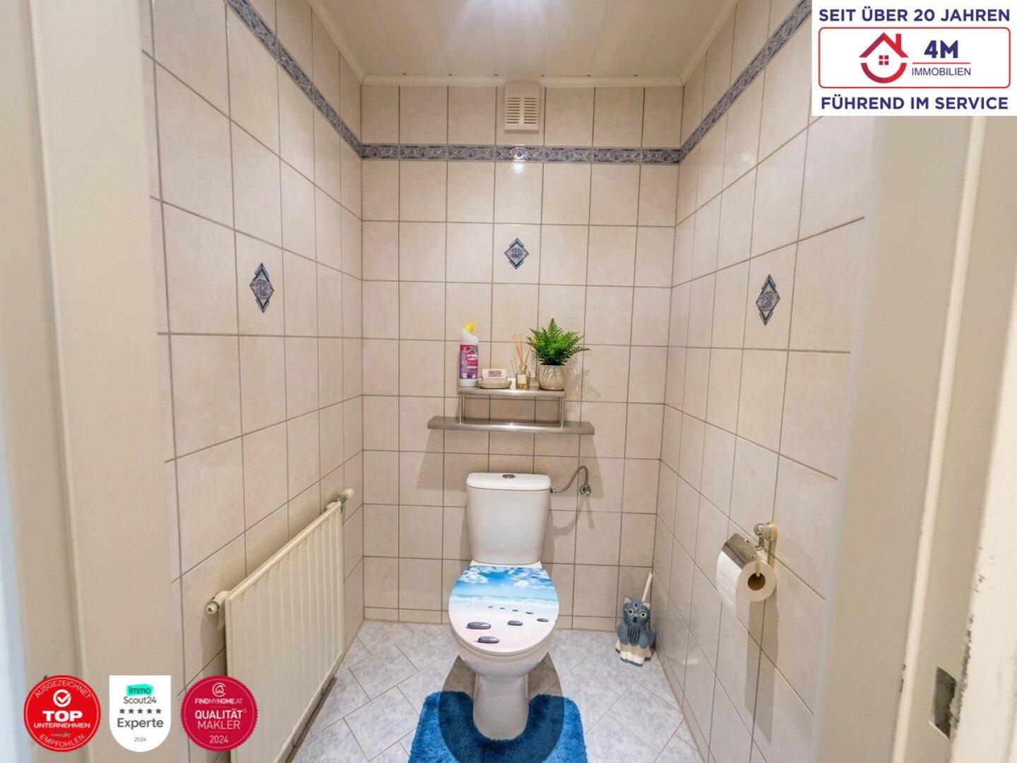 Kleines Gäste-WC mit hellen Fliesen und Heizkörper, funktional eingerichtet.
