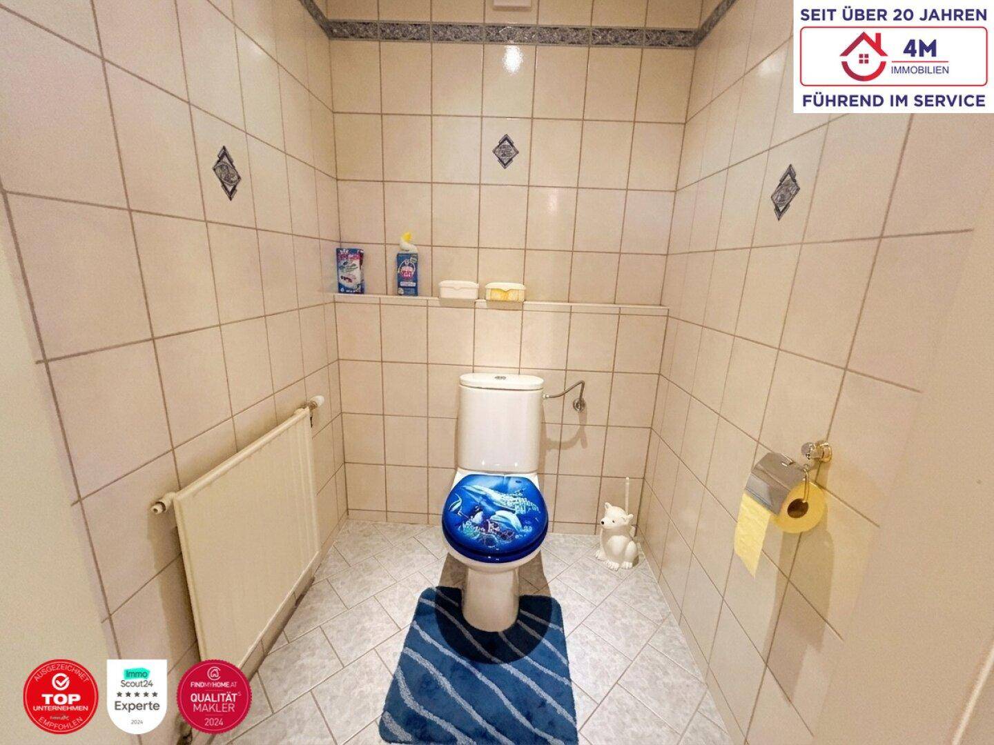Einfaches Gäste-WC mit Fliesen an Wänden und Boden, ausgestattet mit Heizung.