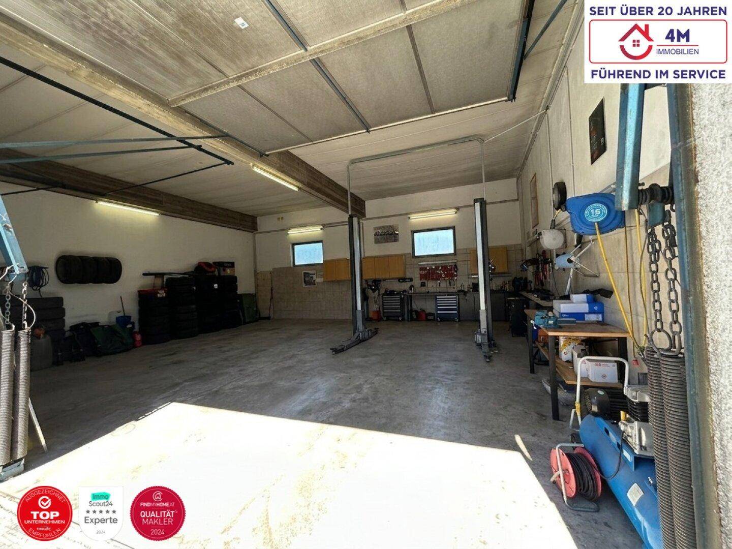 Große Werkstattgarage mit Hebebühne und viel Stauraum für Fahrzeuge und Geräte.