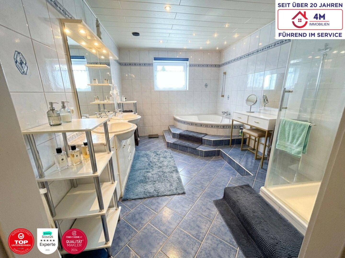 Geräumiges Badezimmer mit blauen Fliesen, Eckbadewanne und separater Duschkabine.