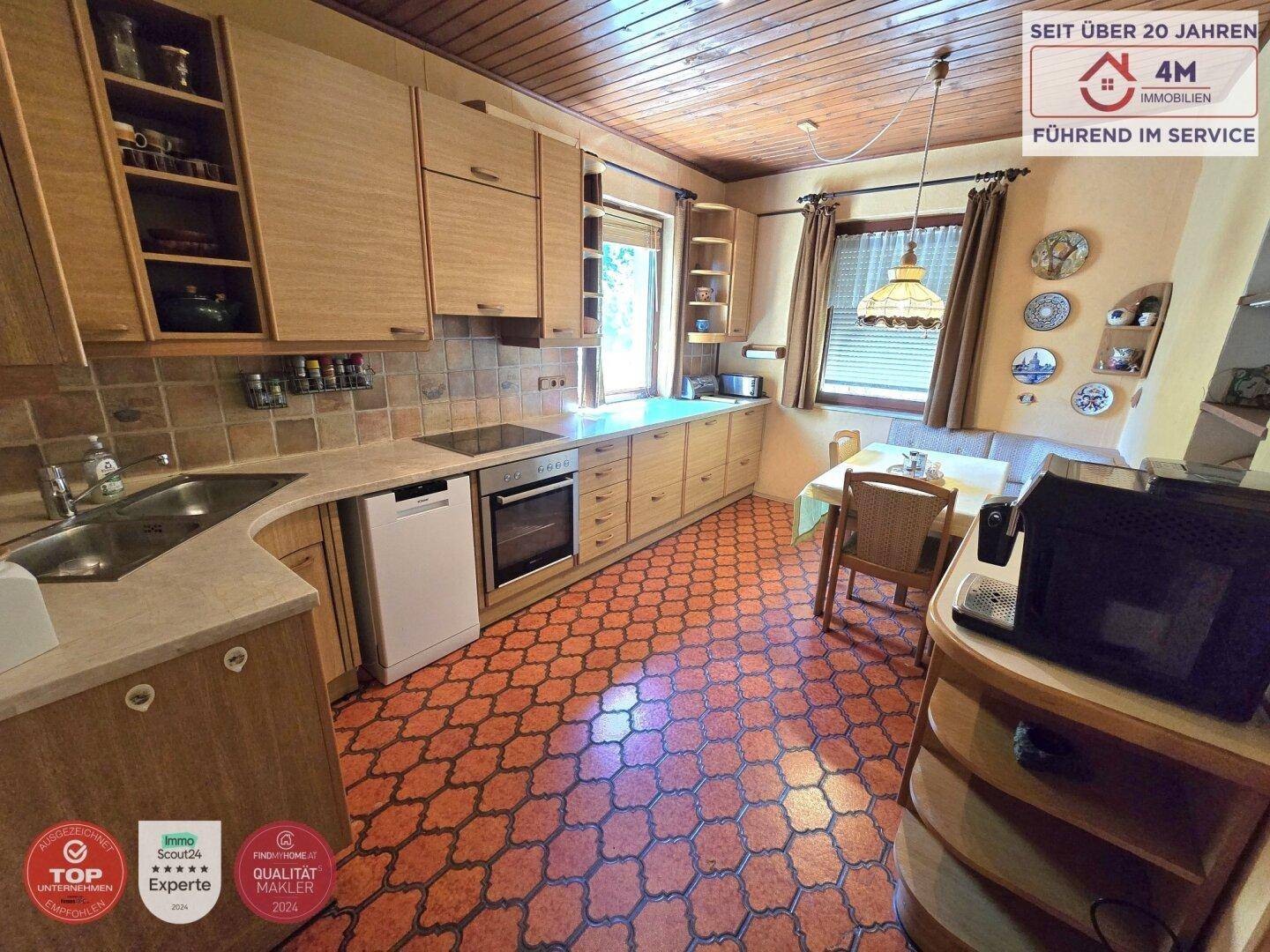 Traditionelle Küche mit Holzschränken, gemusterten Fliesen und einem Essbereich.