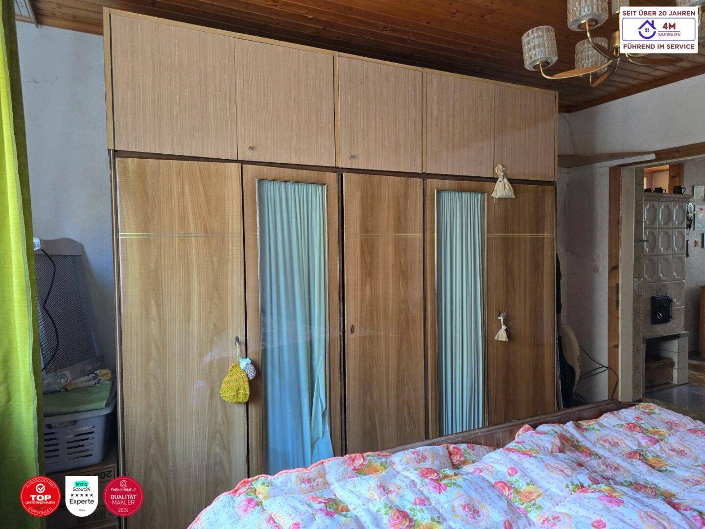 Schlafzimmer mit großem Holzschrank, Doppelbett und einer gemütlichen Decke.