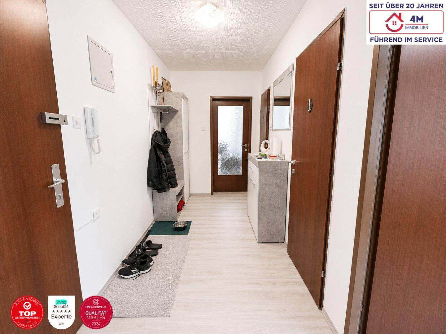 Heller Flur mit Garderobe und Schuhablage, der zu den verschiedenen Räumen der Wohnung führt.