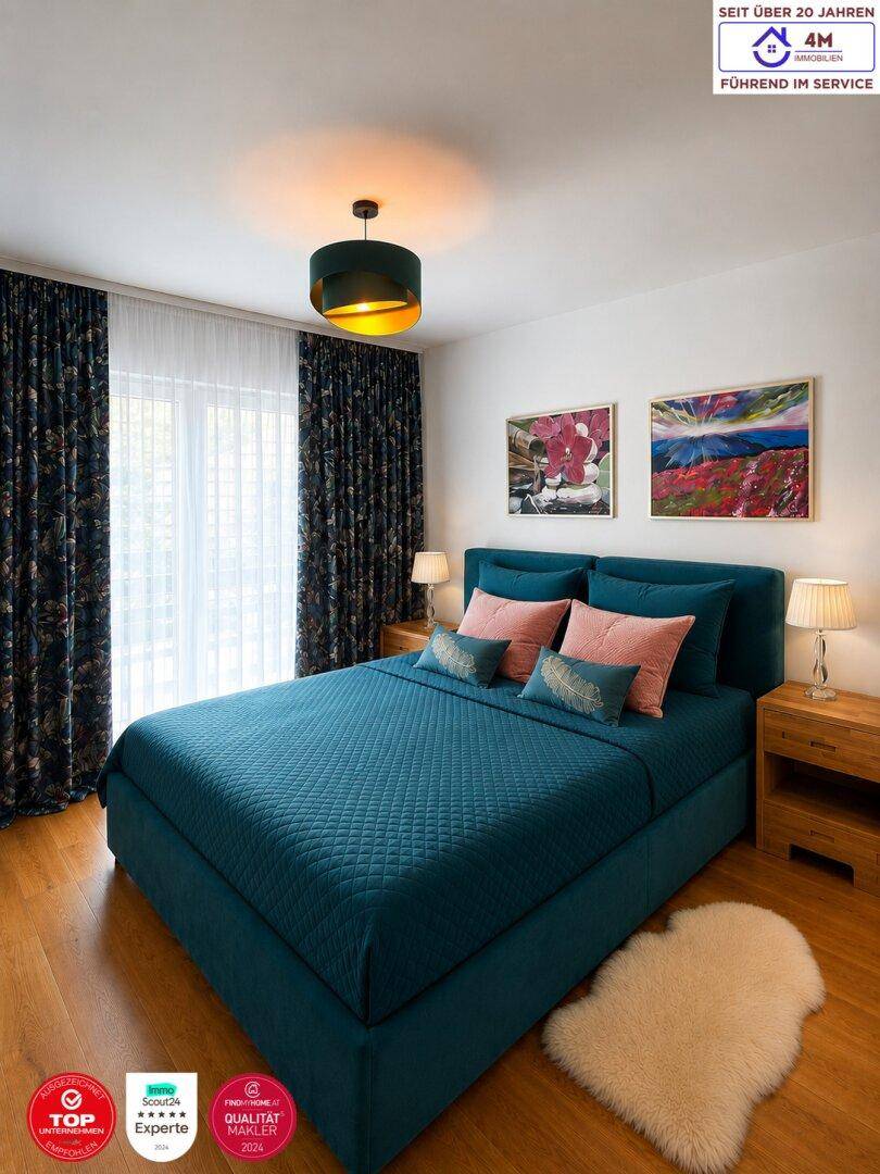 Modernes Schlafzimmer mit blauem Bett, Holzboden und farbenfrohen Bildern an der Wand.