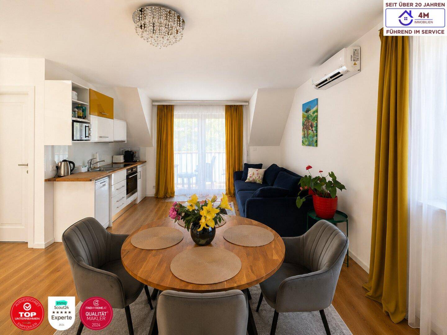 Gemütlicher Wohnbereich mit integrierter Küchenzeile, Esstisch und Zugang zum Balkon.