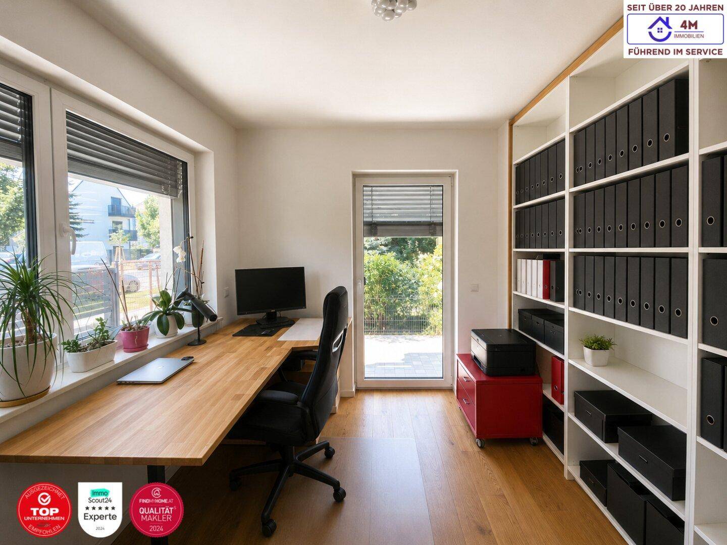 Helles Arbeitszimmer mit großem Schreibtisch, Regalen und Blick ins Grüne.