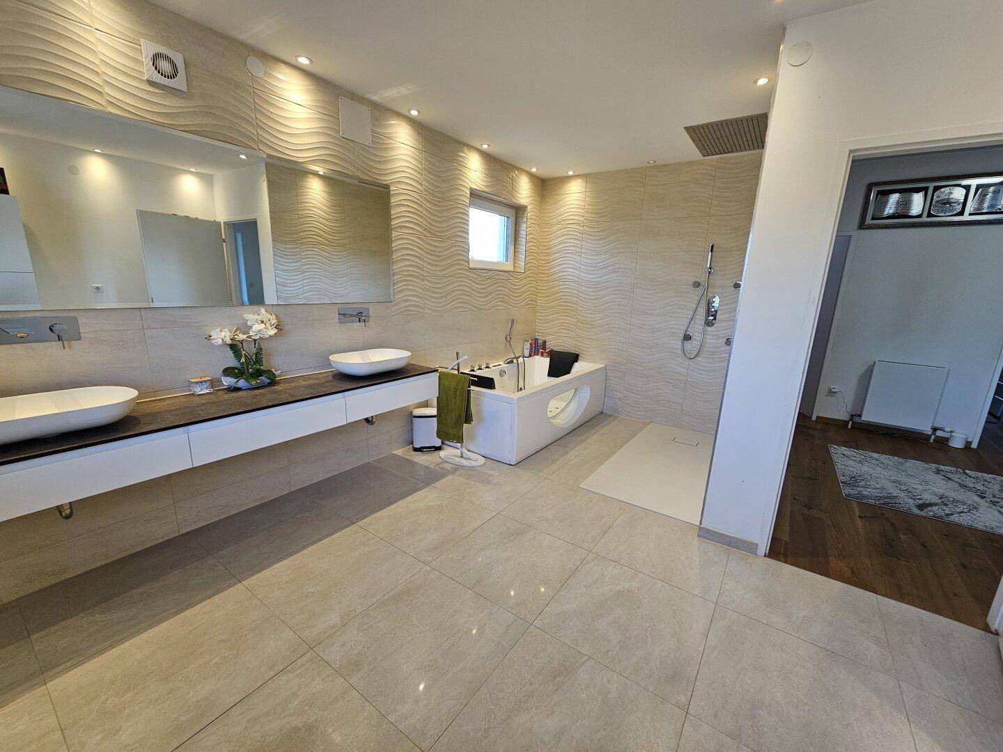 Modernes Badezimmer mit Doppelwaschbecken, Badewanne und ebenerdiger Dusche.