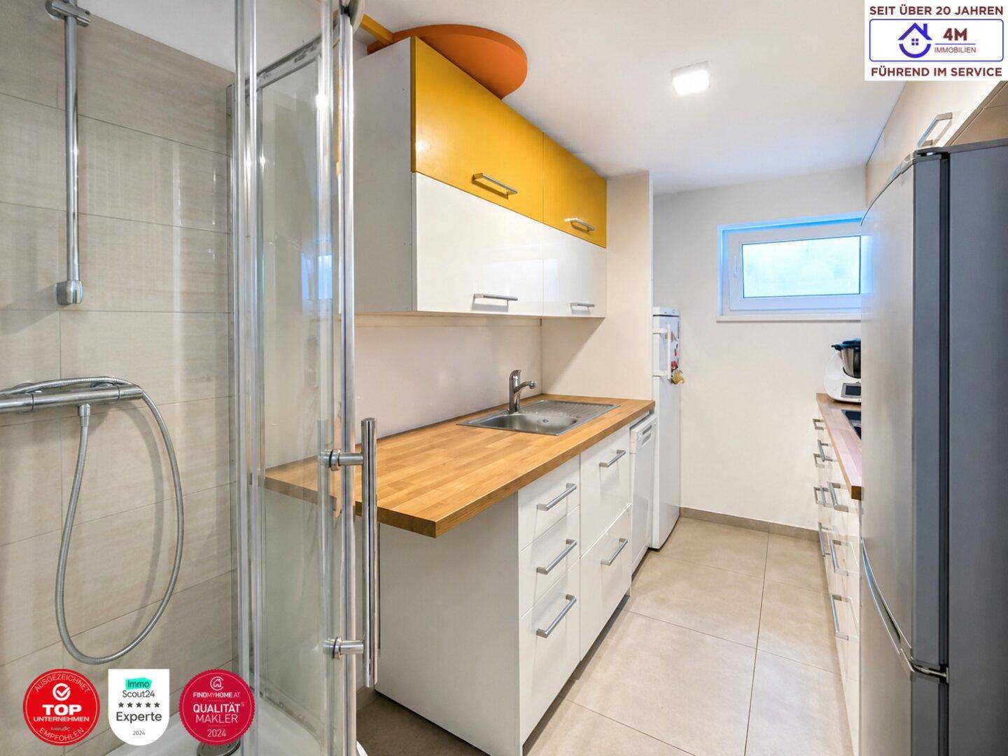 Praktischer Hauswirtschaftsraum mit Waschbecken, Dusche und Stauraum.
