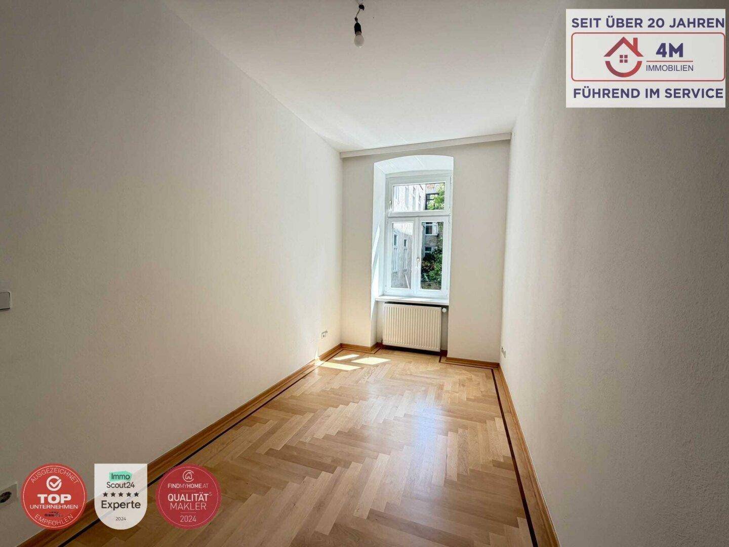 Kleineres Zimmer mit Fischgrätparkett und einem Fenster, das viel Tageslicht bietet.