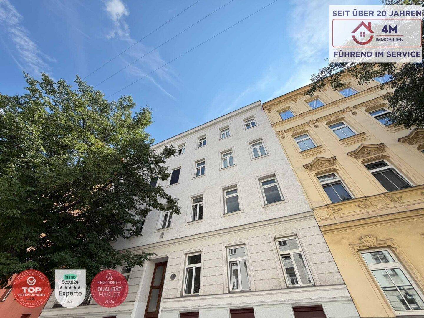 Ansicht der weißen Gebäudefassade mit vielen Fenstern und einem angrenzenden Gebäude.