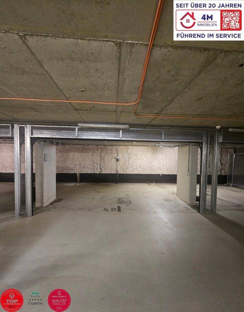 Leerer Stellplatz in einer Tiefgarage mit Betonwänden und -decke.