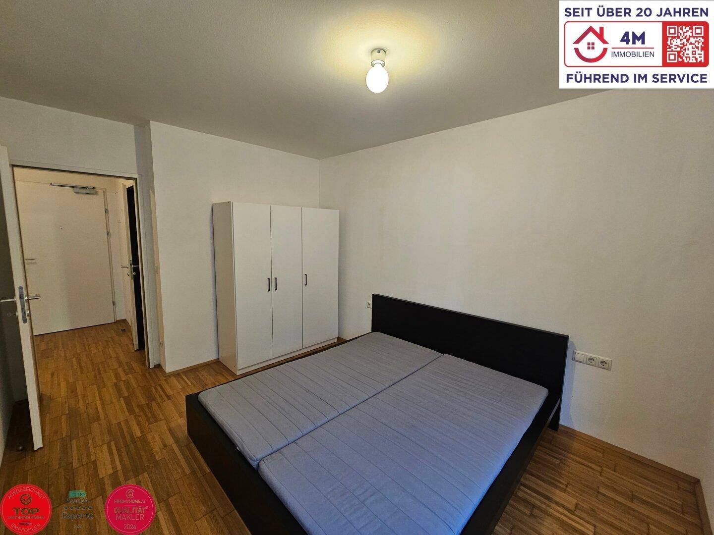 Schlafzimmer mit Doppelbett und Kleiderschrank, der viel Stauraum bietet.