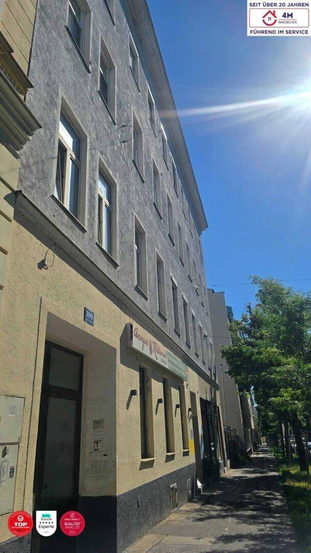 Mehrstöckiges Wohngebäude mit klassischer Fassade und vielen Fenstern unter blauem Himmel.