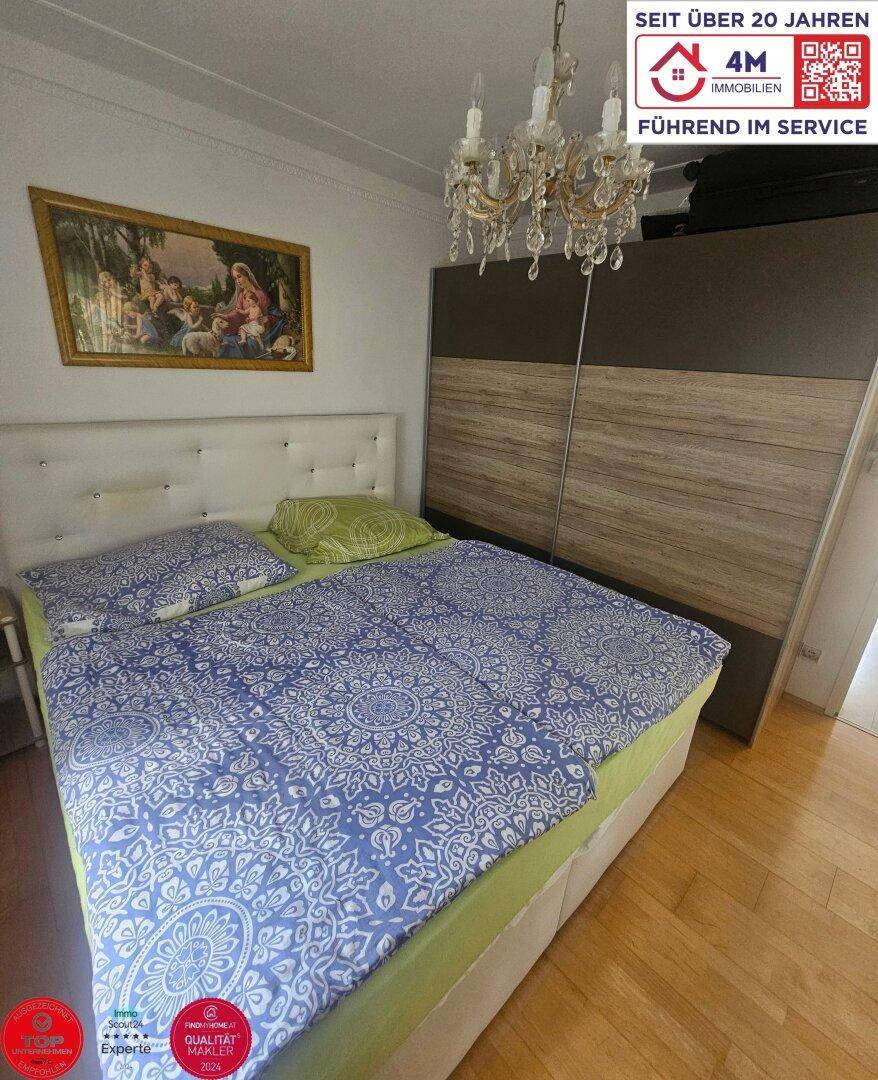 Schlafzimmer mit Doppelbett, Holzboden und großem Kleiderschrank.