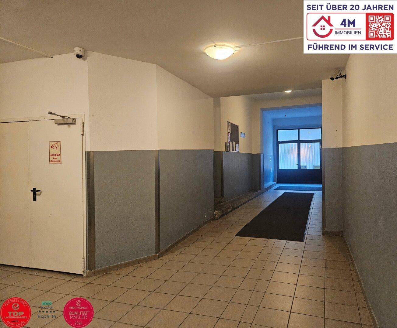 Heller Eingangsbereich mit gefliestem Boden und Zugang zum Treppenhaus.