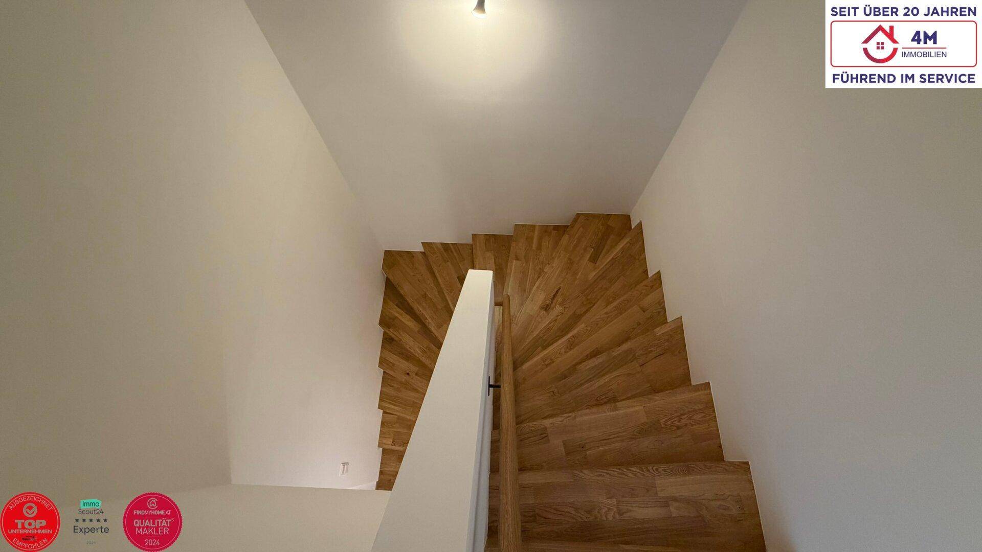 Elegante Holztreppe mit modernem Geländer verbindet die verschiedenen Etagen des Hauses.