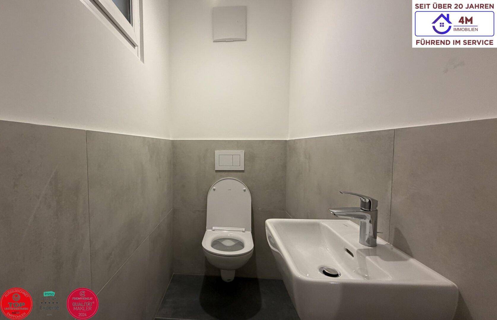 Modernes Gäste-WC mit Wand-WC und kleinem Waschbecken, praktisch und funktional gestaltet.